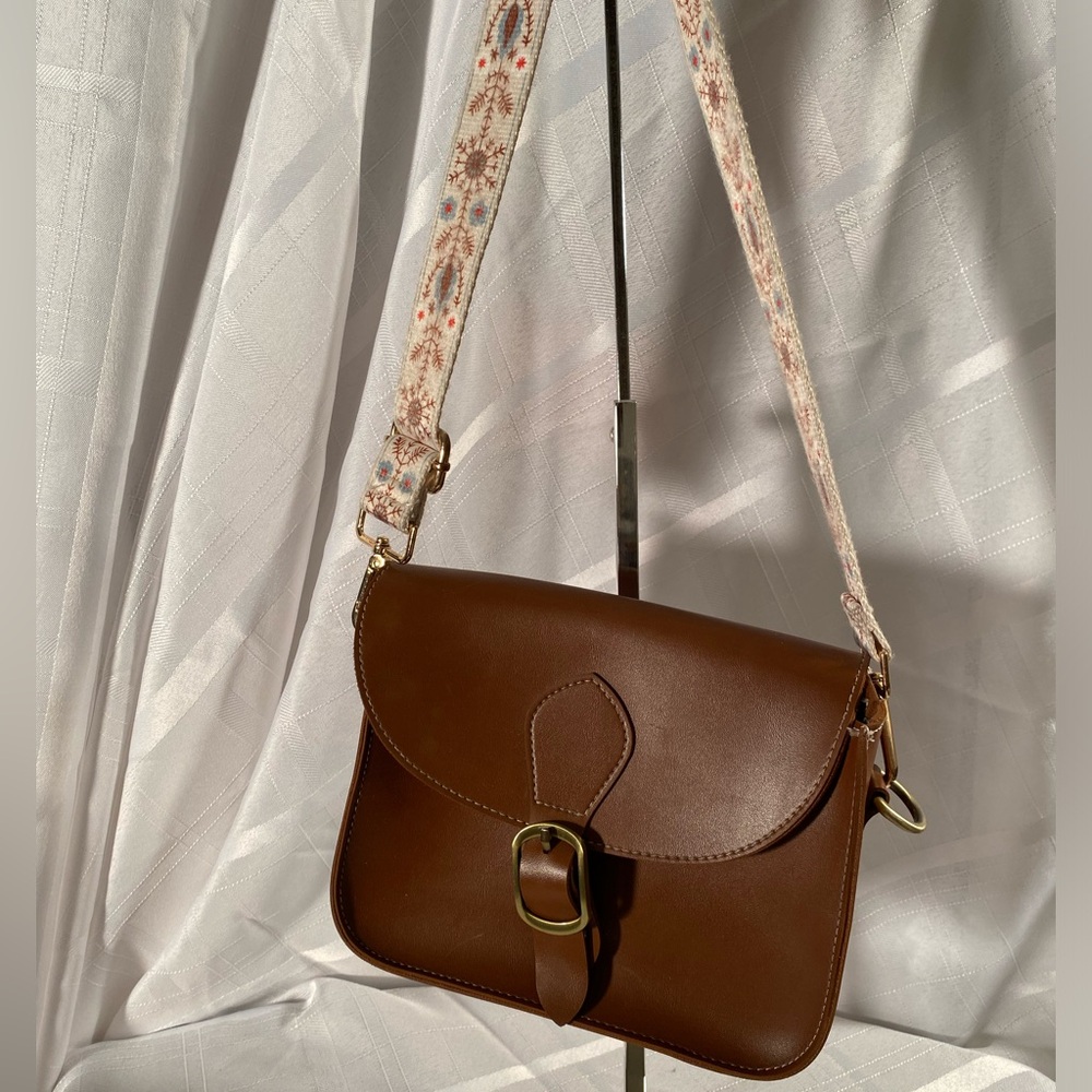Brown, faux leather "Retro Saddle Bag. Flap closure & adjustable shoulder strap.